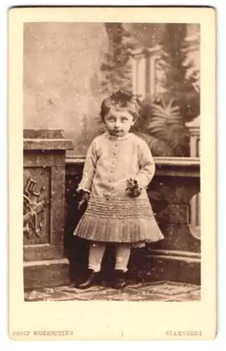 Fotografie Josef Woersching, Starnberg, Kleines Mädchen mit kurzem Haar im Kleid, mit einer Blume in der Hand