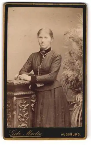 Fotografie Gebr. Martin, Augsburg, Junge Dame mit Halskette und tailliertem Kleid