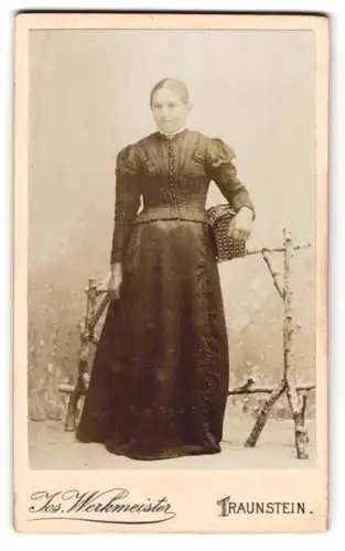 Fotografie Jos. Werkmeister, Traunstein, Ludwigstr. 168, Junge Dame im taillierten Kleid mit einem Korb unterm Arm