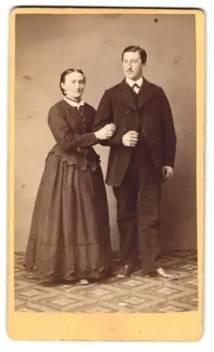 Fotografie A. Gasser, Hall, Bürgerliches Ehepaar, Arm in Arm in ihrem Sonntagsstaat, mit ernsten Blicken