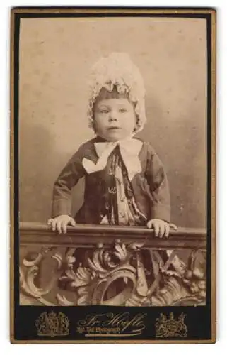 Fotografie Fr. Hoefle, Augsburg, Zeuggasse 226, Kleines Kind mit einer Haube und einem Tuch mit Ankern darauf