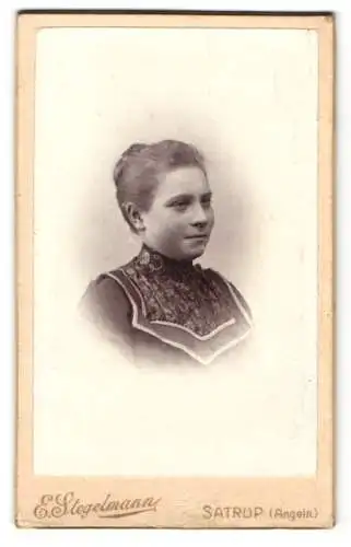 Fotografie E. Stegelmann, Satrup /Angeln, Junge Dame im Kleid über gemusterter Bluse, mit zurückgestecktem Haar