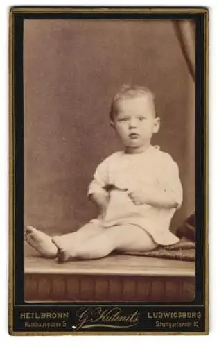 Fotografie G. Kutenits, Ludwigsburg, Stuttgarterstr. 10, Kleines Kind im Hemd mit nackigen Füssen