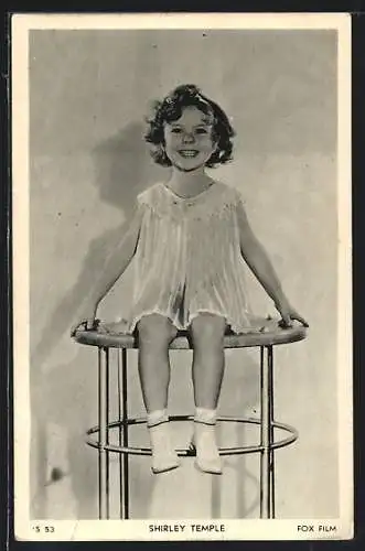 AK Schauspielerin Shirley Temple im Kleid auf einem Tisch sitzend