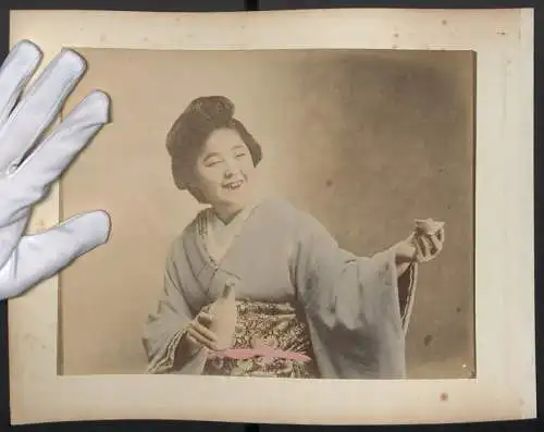 Fotografie unbekannter Fotograf und Ort, junge Japanerin im Kimono schenkt Sake aus, Koloriert, Rückseite Geisha Schirm