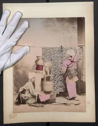 Fotografie unbekannter Fotograf und Ort, junge Geishas beim Wäsche waschen mit Zuber, Rückseite Gruppenfoto, Koloriert
