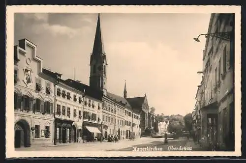 AK Mauerkirchen /Obderdonau, Wachszieherei J. Matzner und der Blick zum Kirchturm