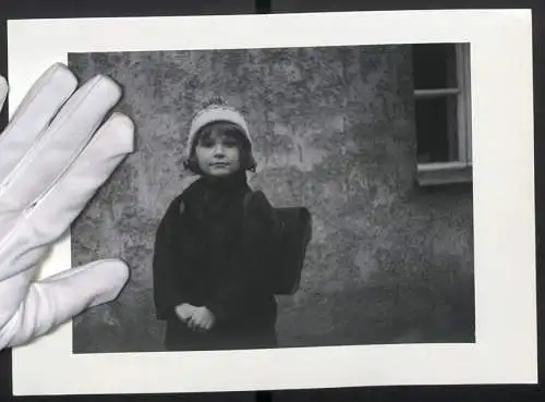 Fotografie unbekannter Fotograf und Ort, niedliches kleines Mädchen zum ersten Schultag mit Ranzen und Bommelmütze