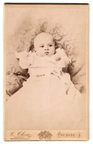 Fotografie C. Clark, Freiburg i. B., Portrait Baby in weissem Taufkleid