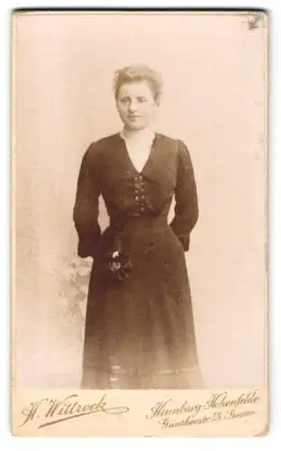 Fotografie H. Wittrock, Hamburg-Hohenfelde, Güntherstr. 73, Hedwig Leschke im schwarzen taillierten Kleid mit Zierblume