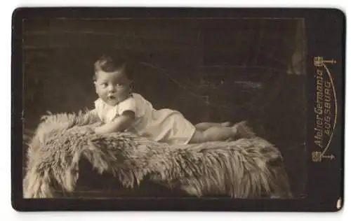 Fotografie Atelier Germania, Augsburg, Bahnhofstr. 12, Jenny Huhs als Baby im weissen Gewand auf einem Pelz