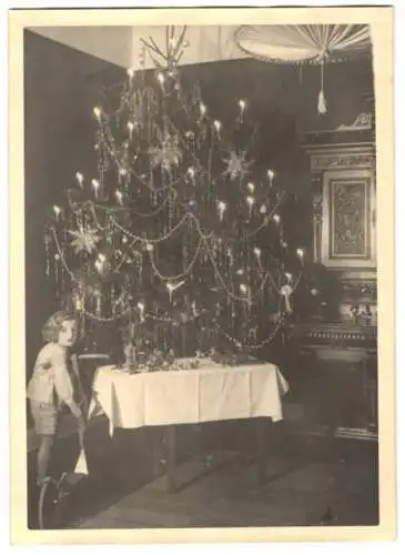 Fotografie Weihnachten, Mädchen mit Tretroller neben Gabentisch mit Lanolin / Elastolin-Spielzeug & Weihnachtsbaum