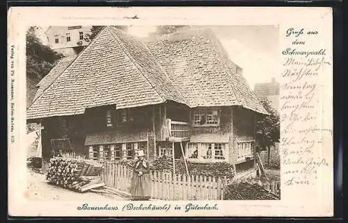 AK Gütenbach i. Schwarzwald, Frau in Tracht vor Bauernhaus Deckerhäusle
