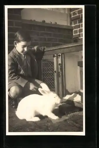 Foto-AK Knabe mit weissem Kaninchen im Garten