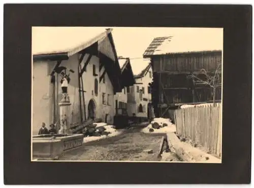 Fotografie unbekannter Fotograf, Ansicht Fiss / Tirol, Strassenansicht mit Brunnenstatue St. Sebastian 1932