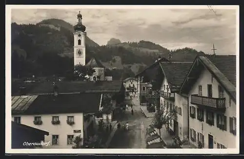 AK Oberaudorf, Strassenpartie mit Passanten und Kirche