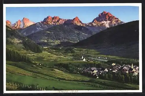 AK Monguelfo, Ortsansicht mit Bergen im Abendlicht