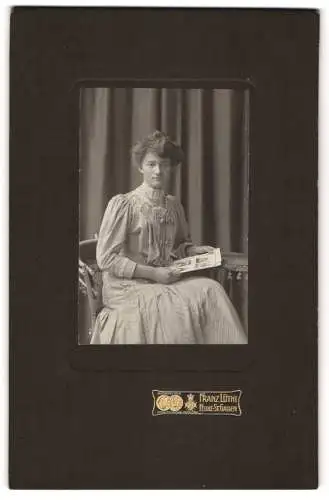 Fotografie Franz Lüthi, Feldle-St. Gallen, Junge Frau in elegantem Kleid mit einer Zeitschrift auf einem Stuhl