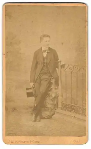 Fotografie J. B. Rottmayer & Comp, Graz, Schönaugasse 9, Junger Mann im schwarzen Anzug mit Zylinder an einem Tor