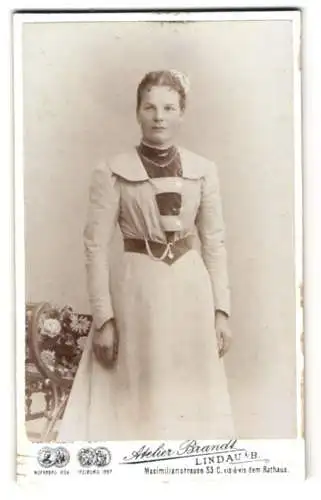 Fotografie Atelier Brandt, Lindau i. B., Maximilianstr. 53, Schwester Rosina im weissen Kleid mit Kette und weissen Blumen