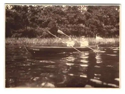 Fotografie junge Menschen im Ruderboot Strolch auf dem See