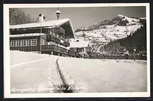 AK Kitzbühel, Alpengasthaus Eichenheim P. A. Hechenberger mit Bergblick im Winter