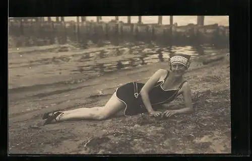 Foto-AK Junge Frau im Badeanzug liegt am Strand
