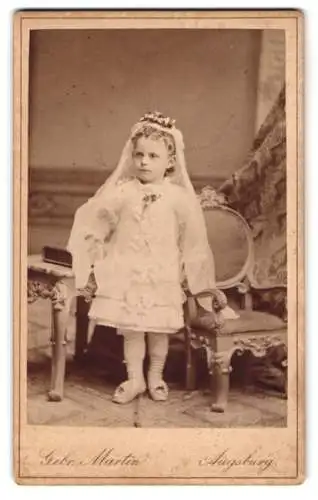 Fotografie Gebr. Martin, Augsburg, niedliches kleines Mädchen zur Erstkommunion im weissen Kleid mit Schleier