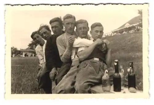 Fotografie unbekannter Fotograf und Ort, sechs junge Männer posieren eng umschlungen mit Bierflaschen, Volksfest