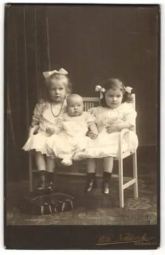 Fotografie Wilh. Nottebrock, Gütersloh, Zwei junge Mädchen und ein Kleinkind, alle in schicken weissen Kleidern