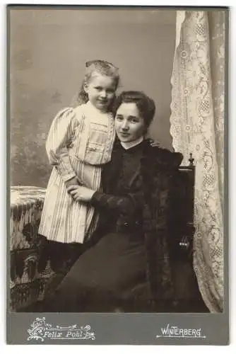 Fotografie Felix Pohl, Winterberg, Junge Mutter mit ihrer jungen Tochter im gestreiften Kleid im Arm