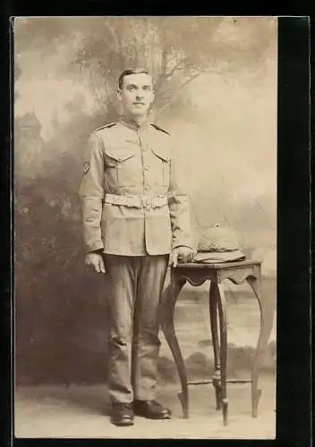 AK Junger britischer Soldat in Uniform, sein Helm auf einem Beistelltisch
