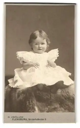 Fotografie Martin Frölich, Flensburg, Norderhofenden 9, Kleines Kind mit süssem Lächeln im weissen Kleid
