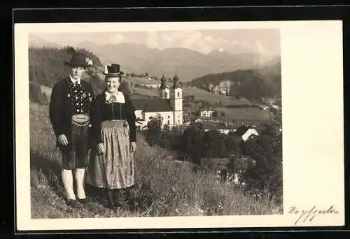AK Ein junges Paar in Tiroler Tracht, im Hintergrund die Kirche