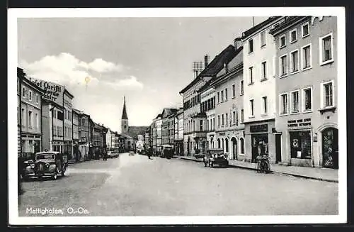AK Mattighofen /O.-Oe., Strassenpartie mit Geschäften und Kirche