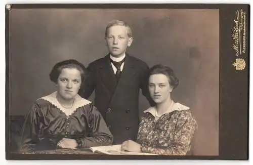 Fotografie M. Fröhlich, Flensburg, Norderhofenden 9, Halbwüchsiger Knabe im Anzug mit zwei jungen Damen