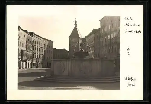 Foto-AK Adalbert Defner: Wels, Abend am Stadtplatz mit Brunnen