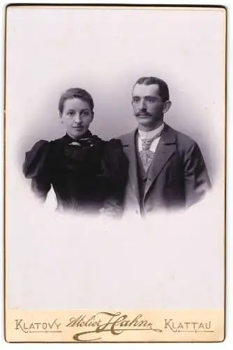 Fotografie Karel Hahn, Klattau, Dlouha ul. 36, Elegantes junges Paar mit ernstem Blick, Puffärmel, Dreiteiler