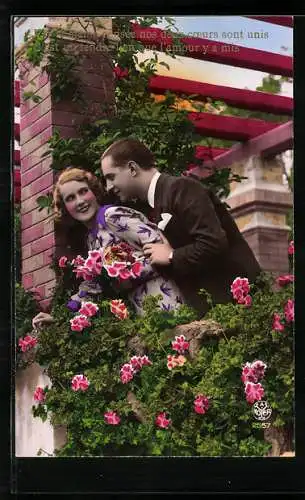 Foto-AK A. Noyer Nr. 2557: Junger Mann im Rosengarten nimmt seine Frau in den Arm