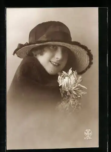 Foto-AK A. Noyer Nr. 2976: Junge schöne Frau im dunklen Mantel mit Hut und weisser Blume