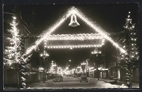 AK Villingen /Schwarzwald, Strassenpartie mit Geschäften u. Festschmuck bei Nacht, Weihnachtsgruss