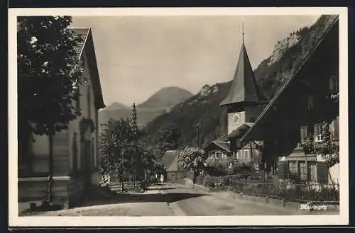 AK Meiringen, Strassenpartie mit Häuser und Kirchturm, Blick auf Berge