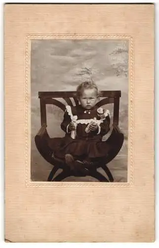 Fotografie unbekannter Fotograf und Ort, Tante Zouzi Meitz als Baby im schwarzen Kleid mit Puppen