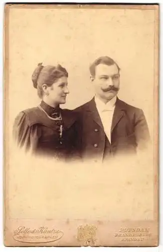 Fotografie Selle & Kuntze, Potsdam, Schwertfegerstr. 14, Grete und James Conrad in feiner schwarzer Kleidung