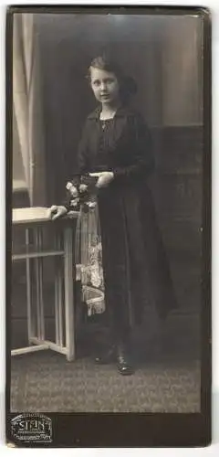 Fotografie Stein, Berlin, Chausseestr. 70, Junge Frau Foerstner im schwarzen Kleid mit Blumenstrauss und Buch