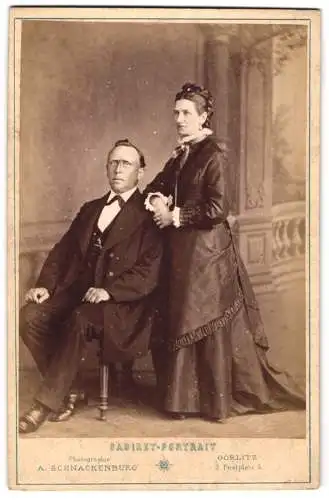 Fotografie A. Schnackenburg, Görlitz, Postplatz 3, Grossmutter Brig im elegantem schwarzen Kleid und Grossvater im Anzug
