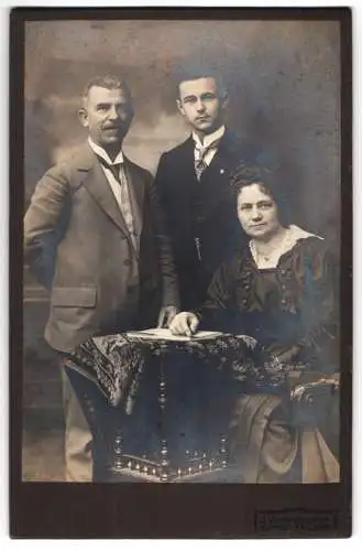 Fotografie J. Werkmeister, Freising, Sigmund, Babette und Sohn Hagl in dunkler Kleidung an einem Tisch