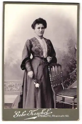Fotografie Gebr. Koschel, Steglitz, Rheinstr. 40, Oma Koppe in jungen Jahren im schwarzen taillierten Kleid mit Rose