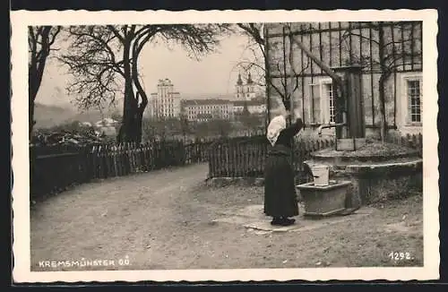 AK Kremsmünster /O.-Ö., Rückenansicht von Frau am Brunnen