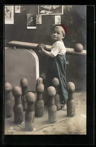 AK Junge steht hintern Kegeln in einer Kegelbahn